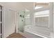 A well-lit bathroom featuring a glass shower and a separate soaking tub under a window at 821 E Chicago St, Chandler, AZ 85225