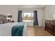 A bright main bedroom showcasing wood-look flooring and a large window view to the backyard at 821 E Chicago St, Chandler, AZ 85225