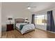 Bedroom featuring a ceiling fan, wood-look floors, and a large window with backyard view at 821 E Chicago St, Chandler, AZ 85225