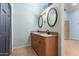 Dual sink bathroom featuring wood cabinets, granite countertops, and framed oval mirrors at 930 E Page St, Gilbert, AZ 85234