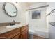 Bathroom featuring a single sink vanity, a round mirror, toilet and a shower/tub combo at 930 E Page St, Gilbert, AZ 85234