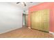 Bright bedroom featuring wood-look flooring, ceiling fan and a closet with gold sliding doors at 930 E Page St, Gilbert, AZ 85234