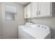 Laundry room featuring white cabinets, a window and white washer and dryer at 930 E Page St, Gilbert, AZ 85234
