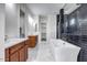A luxurious bathroom featuring a soaking tub, dual vanities, and a separate shower with decorative tile at 9705 E Sector Dr, Mesa, AZ 85212