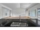 The kitchen boasts sleek dark countertops and stainless steel faucet overlooking the open floorplan at 9705 E Sector Dr, Mesa, AZ 85212