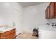 Bright laundry room featuring a sink, tile floors, overhead cabinets, and washer/dryer hookups at 10313 W Windsor Ave, Avondale, AZ 85392