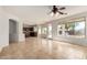 Open living room with tile floors, large windows, and an open doorway to the kitchen at 10313 W Windsor Ave, Avondale, AZ 85392