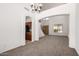 Open-concept living space with a chandelier, arched entryways, and a staircase at 10313 W Windsor Ave, Avondale, AZ 85392