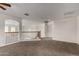Spacious carpeted loft with arched entryway, railing, and access to other rooms at 10313 W Windsor Ave, Avondale, AZ 85392