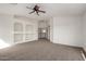 Spacious loft featuring built-in shelves and an open floor plan with carpeted flooring at 10313 W Windsor Ave, Avondale, AZ 85392