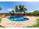 Inviting backyard pool with lush landscaping, palm trees, and beautiful waterfall feature at 10313 W Windsor Ave, Avondale, AZ 85392