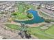 Aerial view of a golf course and a winding lake surrounded by residential homes in the community at 11550 W Mule Deer Ct, Surprise, AZ 85378