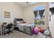Cozy bedroom featuring a neutral color scheme, a desk, and a large window, perfect for study and sleep at 11550 W Mule Deer Ct, Surprise, AZ 85378
