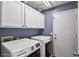 Laundry room with full size washer and dryer, plus white cabinets above with dark hardware at 11550 W Mule Deer Ct, Surprise, AZ 85378