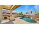Inviting backyard featuring a built-in grill and a sparkling pool perfect for outdoor entertaining under a blue sky at 13614 N 12Th Way, Phoenix, AZ 85022