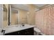 Well-lit bathroom with a black vanity, white countertop, large mirror, and stylish shower curtain for an elegant touch at 13614 N 12Th Way, Phoenix, AZ 85022