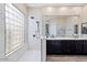 Modern bathroom featuring a glass block shower, dual sinks, and sleek black cabinetry with updated fixtures at 13614 N 12Th Way, Phoenix, AZ 85022