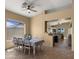 Well-lit dining area with a modern ceiling fan and view into the kitchen and living room with tile flooring throughout at 13614 N 12Th Way, Phoenix, AZ 85022