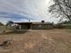 View of expansive back yard with dirt landscaping, mature tree, block fence, and covered patio at 1404 S Spencer --, Mesa, AZ 85204