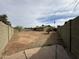 View of expansive back yard with dirt landscaping, mature tree, and block fence at 1404 S Spencer --, Mesa, AZ 85204