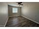 This bright bedroom features wood-look flooring and a ceiling fan, creating a comfortable and inviting living space at 1404 S Spencer --, Mesa, AZ 85204