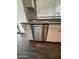 Modern kitchen with stainless steel dishwasher and white cabinets, complemented by stylish wood flooring and natural light from the window at 1404 S Spencer --, Mesa, AZ 85204