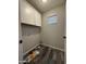 This laundry room has white cabinets, neutral walls, and wood-look floors, offering a clean and functional space at 1404 S Spencer --, Mesa, AZ 85204