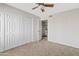 Carpeted bedroom featuring light walls, a ceiling fan, and a white closet at 1411 W Mendoza Ave, Mesa, AZ 85202