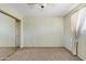 Neutral bedroom featuring carpet, a ceiling fan, and a large closet with mirrored doors at 1411 W Mendoza Ave, Mesa, AZ 85202