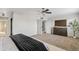 Spacious bedroom with neutral carpet, ceiling fan, and a TV; access to the bathroom and closet at 1411 W Mendoza Ave, Mesa, AZ 85202