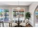 Cozy breakfast nook with a glass table, comfortable seating, and views of the sparkling pool outside at 1411 W Mendoza Ave, Mesa, AZ 85202