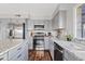 Updated kitchen with stainless steel appliances, granite countertops, stylish gray cabinets, and modern fixtures at 1411 W Mendoza Ave, Mesa, AZ 85202