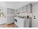 Laundry room with gray cabinets, granite countertops, modern washer and dryer, and access to the backyard at 1411 W Mendoza Ave, Mesa, AZ 85202