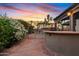 Outdoor kitchen and bar area with a view of the sparkling pool and desert landscaping at 1411 W Mendoza Ave, Mesa, AZ 85202