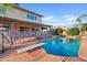 Backyard pool area surrounded by a stone patio, waterfall feature, and lush landscaping at 1411 W Mendoza Ave, Mesa, AZ 85202
