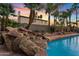 Pool with rock waterfall feature, mature landscaping, and a view of the home at 1411 W Mendoza Ave, Mesa, AZ 85202