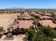An elevated view showcasing a residential area with Spanish tile roofs, lush landscaping and desert mountain views in the distance at 14250 W Wigwam Blvd # 121, Litchfield Park, AZ 85340