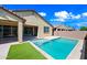 Backyard features pool with baja shelf, well-kept artificial grass and perimeter concrete border at 14413 W Eugene Ter, Surprise, AZ 85379