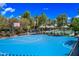 Bright blue basketball court surrounded by landscaping, with neighborhood pool visible in the background at 14413 W Eugene Ter, Surprise, AZ 85379