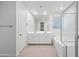 Modern bathroom boasts double sinks, a soaking tub, glass-enclosed shower, and tile flooring at 14413 W Eugene Ter, Surprise, AZ 85379