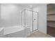 Well-lit bathroom featuring a soaking tub with a walk-in shower and white cabinets at 14413 W Eugene Ter, Surprise, AZ 85379