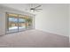 Spacious carpeted bedroom with sliding glass doors, a ceiling fan, and backyard views at 14413 W Eugene Ter, Surprise, AZ 85379