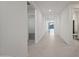 Bright hallway featuring neutral tones, sleek flooring, and access to various rooms in the home at 14413 W Eugene Ter, Surprise, AZ 85379