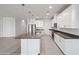 Modern kitchen features white cabinetry, stainless appliances, island, and stylish pendant lighting at 14413 W Eugene Ter, Surprise, AZ 85379