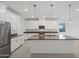 Bright kitchen with white cabinets, stainless steel appliances, undermount sink, and pendant lighting above island at 14413 W Eugene Ter, Surprise, AZ 85379