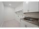Neat laundry room with sink, tile floors, and built-in shelves at 14413 W Eugene Ter, Surprise, AZ 85379