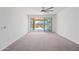 Bright living room featuring carpeted floors and sliding glass doors to the outdoor kitchen at 14413 W Eugene Ter, Surprise, AZ 85379