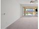 Bright living room featuring carpeted floors and sliding glass doors to the outdoor kitchen at 14413 W Eugene Ter, Surprise, AZ 85379