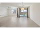 Open living room boasts neutral walls, tile floors, modern fan and sliding glass door to backyard pool area at 14413 W Eugene Ter, Surprise, AZ 85379