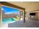 Inviting covered patio featuring a pool, outdoor kitchen, built-in grill and fireplace with TV hookups at 14413 W Eugene Ter, Surprise, AZ 85379